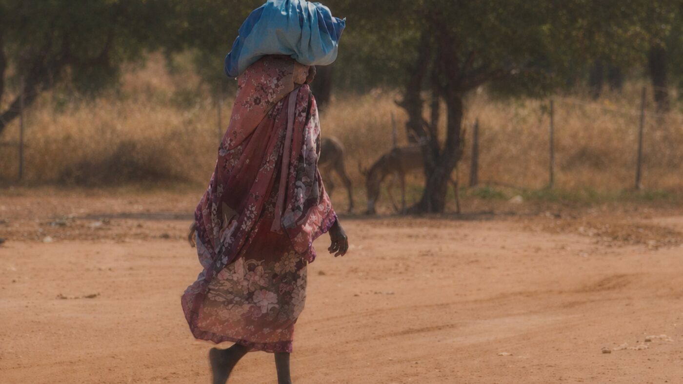 donna che cammina nel campo di Daguessa, in Ciad